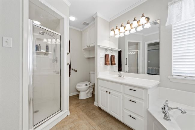 Full bath with a shower stall, tile patterned floors, visible vents, vanity, and ornamental molding | Image 20