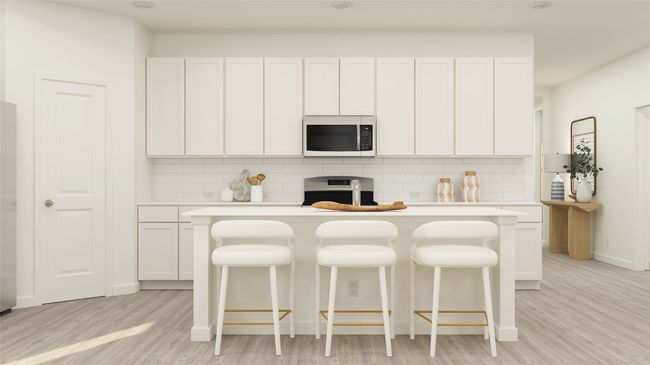 Kitchen with stainless steel microwave, stove, light countertops, and backsplash | Image 9