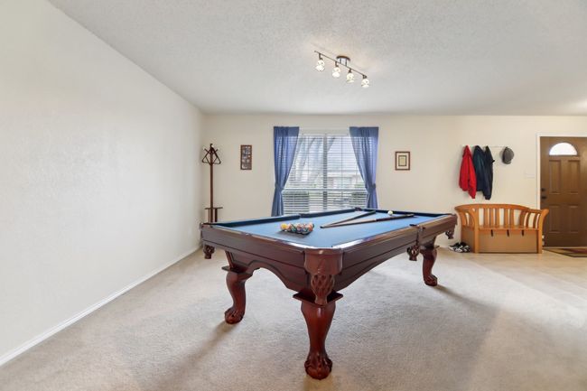 Playroom with light colored carpet, pool table, baseboards, and a textured ceiling | Image 13