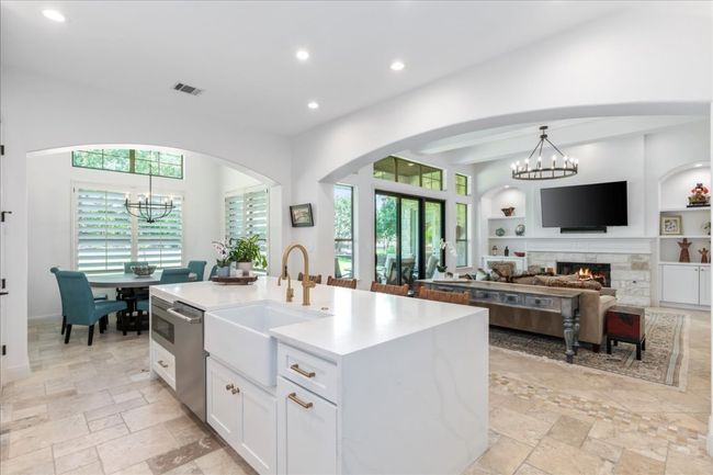 Kitchen with a sink, a chandelier, recessed lighting, white cabinetry, and stainless steel dishwasher | Image 6