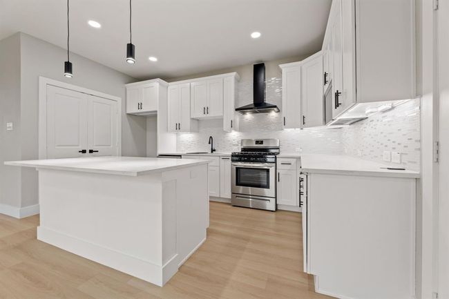 Chef’s dream kitchen. The large quartz island and high-end stainless steel appliances make this kitchen the heart of the home. | Image 6