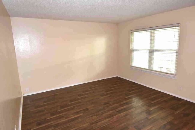 Spare room with dark wood-type flooring, a textured ceiling, and baseboards | Image 10