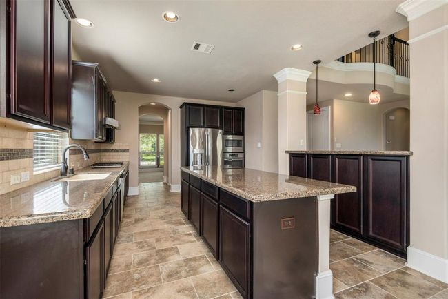 Warm and inviting island kitchen with stainless appliances and tons of storage and counter space. Fridge included. | Image 15