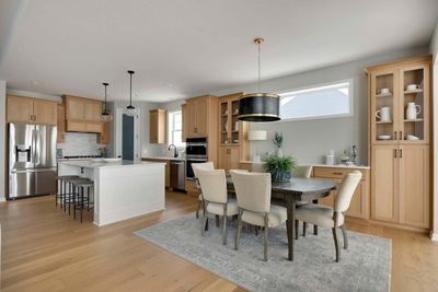 Gourmet kitchen with wood hood, walk-in pantry, enlarged island with extra cabinets for storage and stainless appliances with built in oven and microwave. Inspiration photos from another Stirling plan model home. | Image 3