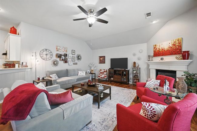 This home is set up to entertain. The gorgeous living room has a corner gas fireplace and windows that overlook the yard. It's an ideal spot to host guests, and this room makes having friends and family around easy. | Image 6