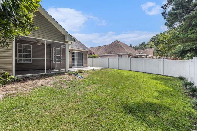 Fenced backyard with a patio and ceiling fan | Image 36