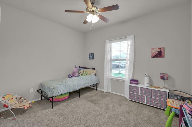 This secondary bedroom is located on the first floor and has a view of the front yard. | Image 20