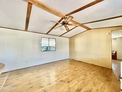 SPACIOUS LIVING ROOM WITH VAULTED BEAMED CEILINGS AND WOOD LAMINATE FLOORS | Image 3