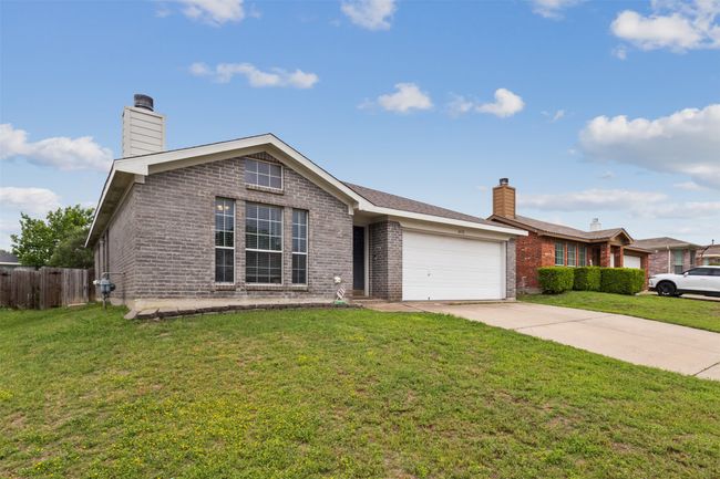 Ranch-style home with a chimney, driveway, a garage, and brick siding | Image 4