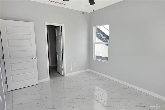 Unfurnished bedroom featuring marble finish floor and baseboards | Image 13