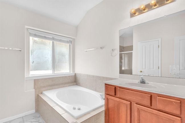 Bathroom with a bath, a shower stall, vanity, and lofted ceiling | Image 18