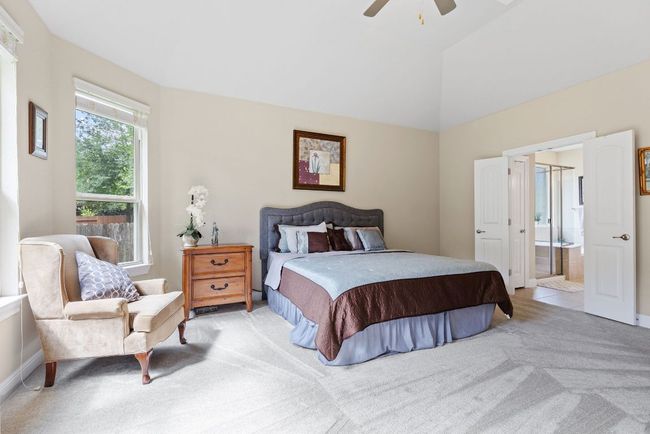 Bedroom featuring light carpet, connected bathroom, ceiling fan, and lofted ceiling | Image 4