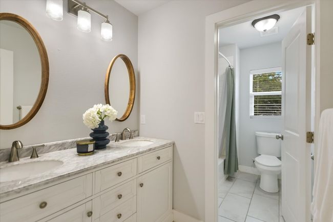 Full bathroom featuring double vanity and shower / bath combination with easy access from all upstairs bedrooms | Image 19