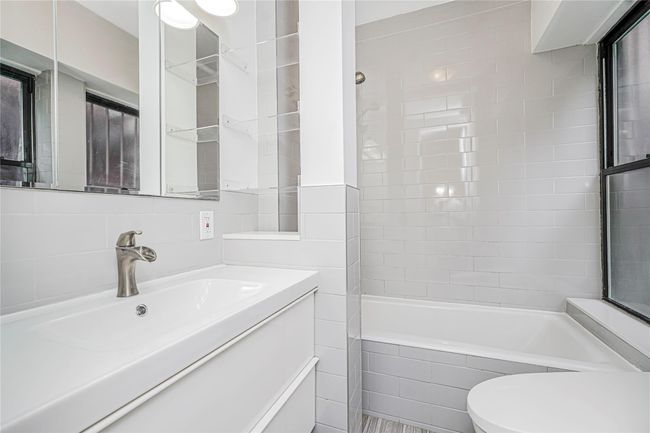 Bathroom featuring vanity, tub / shower combination, and tile walls | Image 16