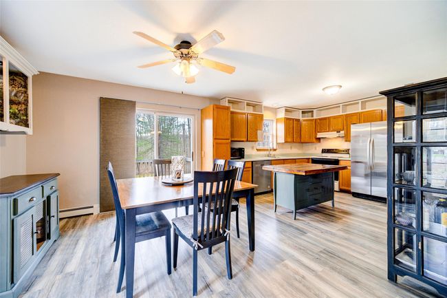 Dining area with light wood-style floors, baseboard heating, and ceiling fan | Image 8