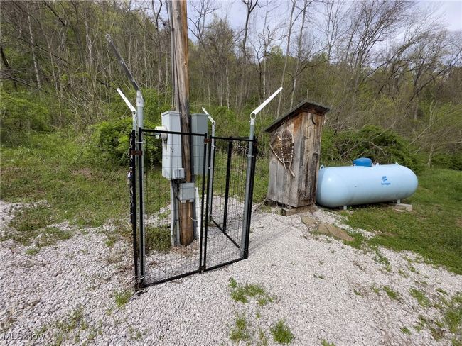 View of gate featuring a view of trees | Image 6