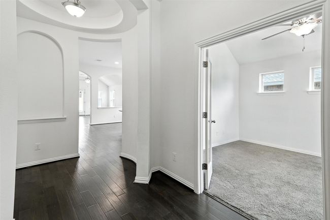 Corridor with dark wood-style floors and arched walkways | Image 6