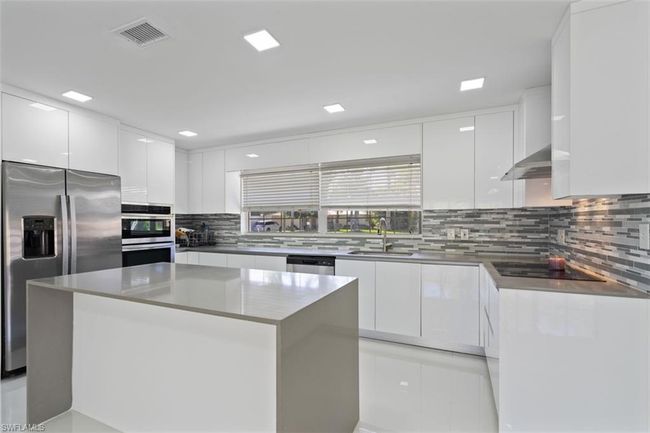 Kitchen with visible vents, modern cabinets, a sink, stainless steel appliances, and white cabinets | Image 7