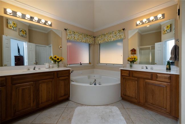 Bathroom with two vanities, a bath, a stall shower, and a sink | Image 30