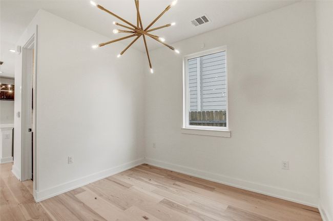 Empty room featuring a chandelier, light wood-style flooring, and baseboards | Image 13