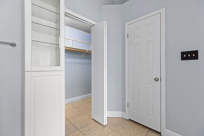 Just beyond the bath, a Walk-in Closet stands ready for your daily rhythm. Shelving, hanging space, and a little extra room to move around. | Image 25