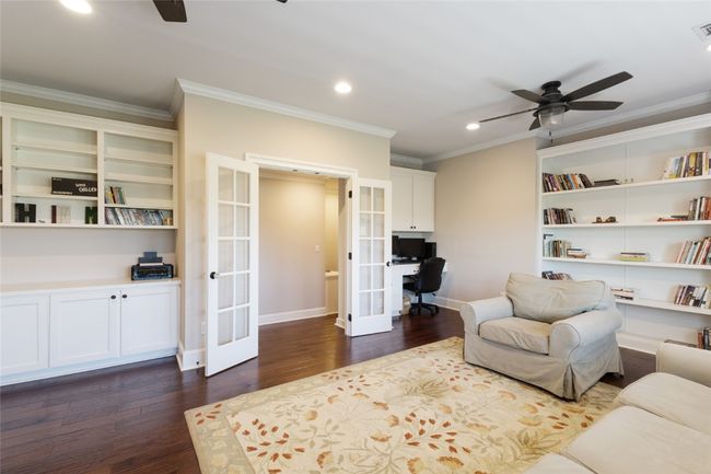 Living area with french doors, ceiling fan, a desk, dark wood finished floors, and crown molding | Image 19