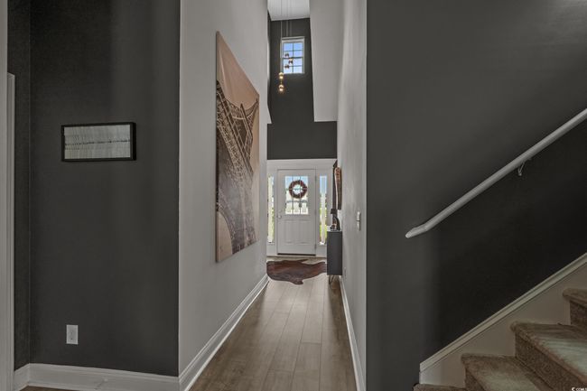 Corridor with wood finished floors, stairs, plenty of natural light, and a high ceiling | Image 5