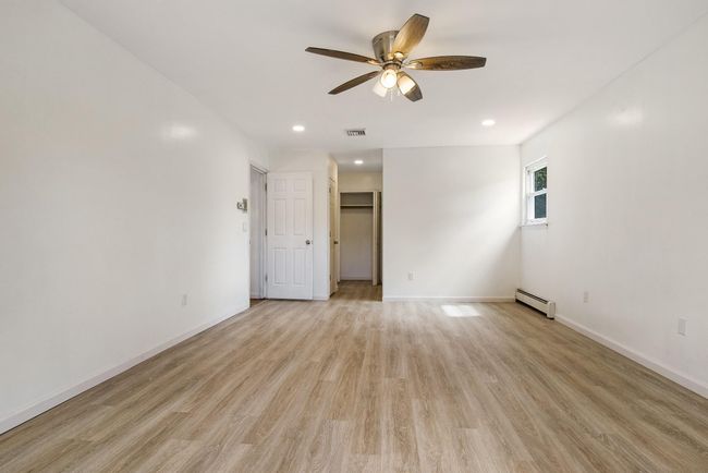 Empty room featuring a baseboard heating unit, ceiling fan, light wood-style flooring, recessed lighting, and baseboards | Image 25