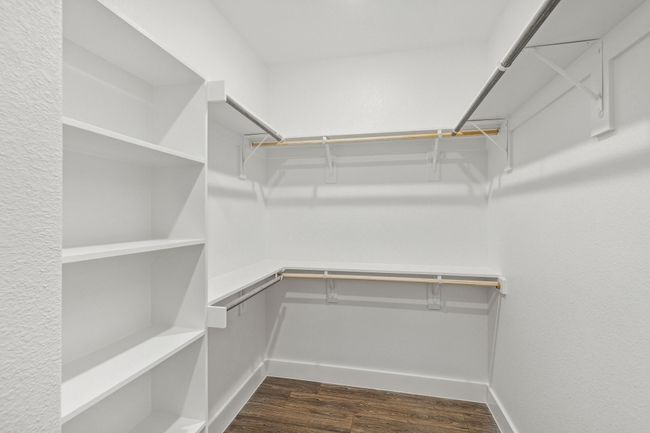 Walk in closet featuring dark wood-style flooring | Image 24