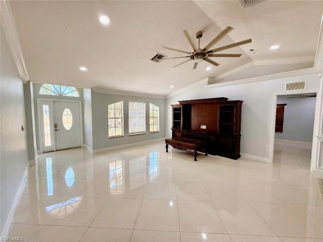 Entrance foyer with baseboards, visible vents, a ceiling fan, and crown molding | Image 6