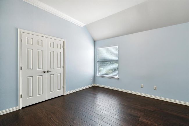 Unfurnished bedroom featuring dark hardwood / wood-style flooring, lofted ceiling, and crown molding | Image 25