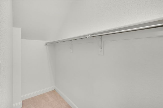 Walk in closet featuring light colored carpet | Image 18