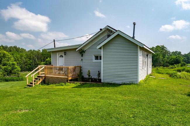 Rear view of house with a deck and a lawn | Image 40