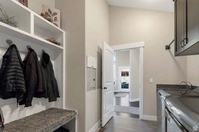 Laundry area featuring wood finished floors, a sink, baseboards, cabinet space, and washer and clothes dryer | Image 19