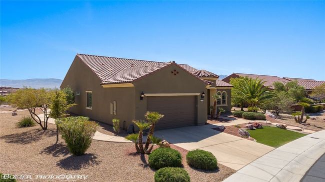View of front of house featuring an attached garage, a tiled roof, concrete driveway, and stucco siding | Image 4
