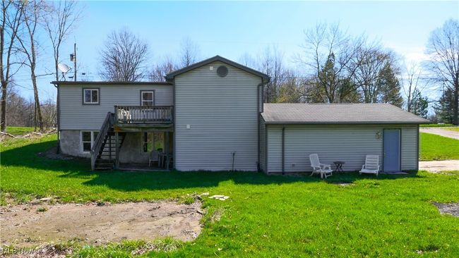 Rear view of property featuring stairway, a deck, and a yard | Image 32