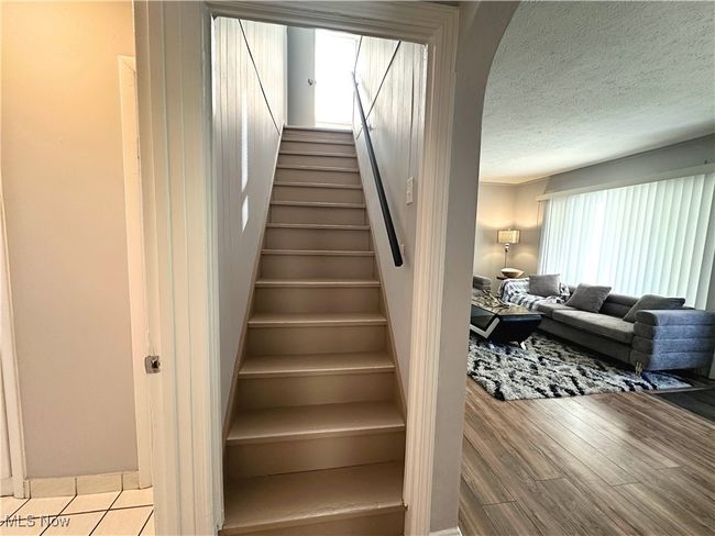 Stairs featuring wood finished floors and a textured ceiling | Image 8