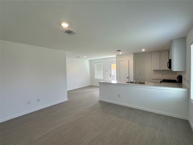 Kitchen with wood finished floors, recessed lighting, a peninsula, range with gas cooktop, and light countertops | Image 6