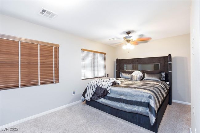 Bedroom featuring baseboards, a ceiling fan, visible vents, and carpet floors | Image 30