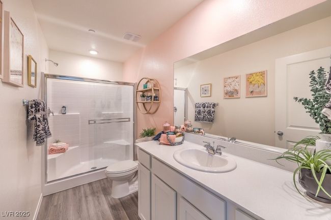Bathroom with vanity, toilet, a stall shower, visible vents, and wood finished floors | Image 25