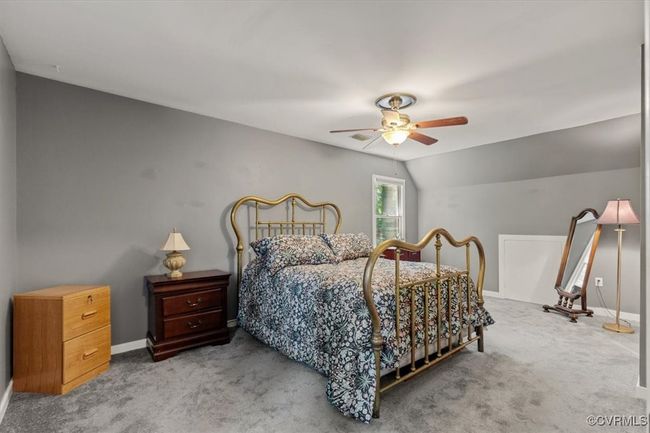 Bedroom featuring carpet floors, a ceiling fan, lofted ceiling, and baseboards | Image 35