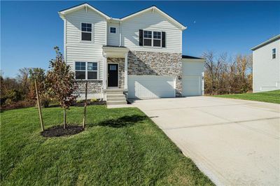 View of property featuring a front yard and a garage | Image 1