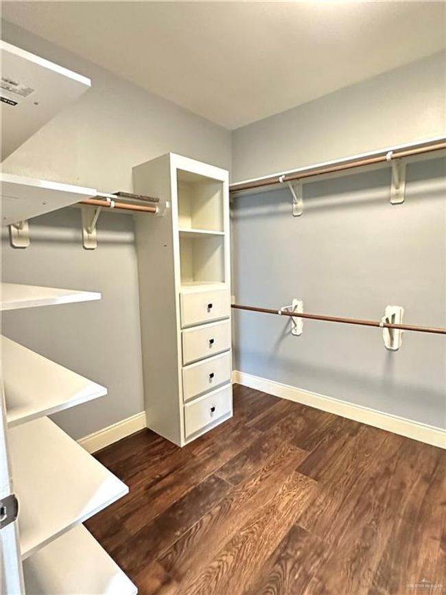 Spacious closet with dark wood finished floors | Image 15