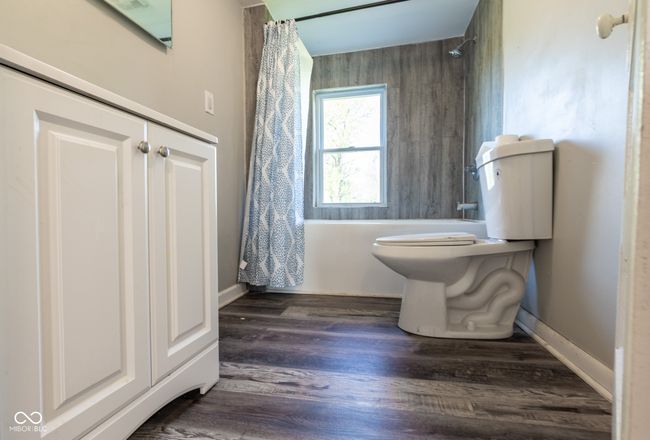 bathroom with baseboards, toilet, and wood finished floors | Image 33
