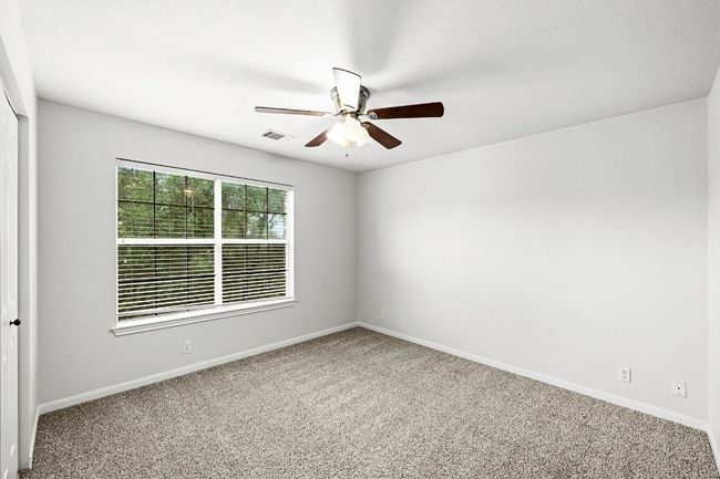 Carpeted empty room featuring ceiling fan and baseboards | Image 15