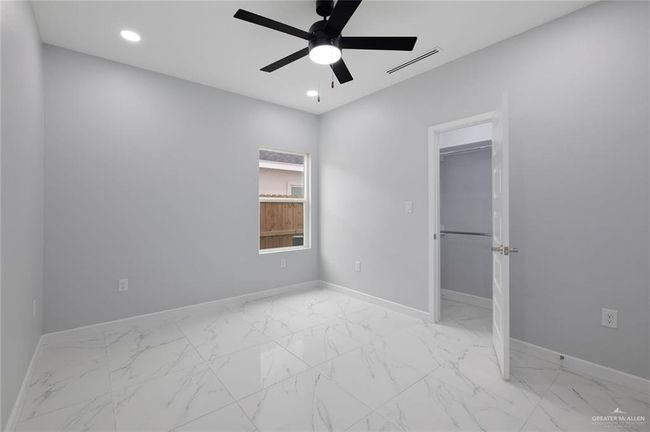 Unfurnished bedroom with baseboards, light marble finish flooring, recessed lighting, and ceiling fan | Image 12