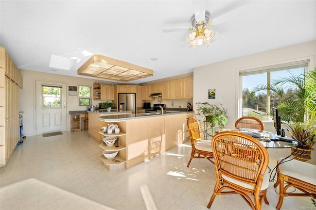Spacious kitchen features stainless steel appliances, a sizeable island, and a cozy breakfast nook—perfect for gathering and entertaining. | Image 5