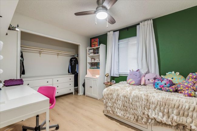 Bedroom featuring a ceiling fan, a closet, light wood finished floors, and a textured ceiling | Image 14