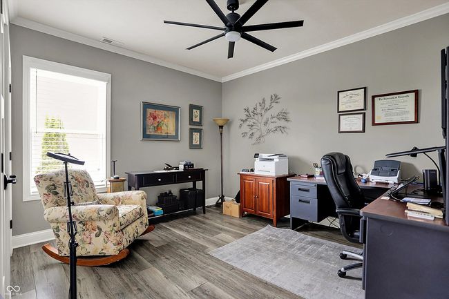 home office featuring dark wood finished floors, visible vents, ornamental molding, baseboards, and ceiling fan | Image 36