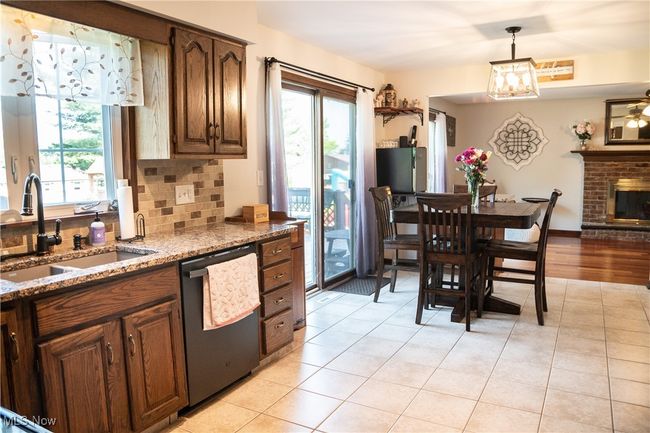 Kitchen with dishwasher, light tile patterned flooring, light granite countertops, and pendant lighting | Image 20